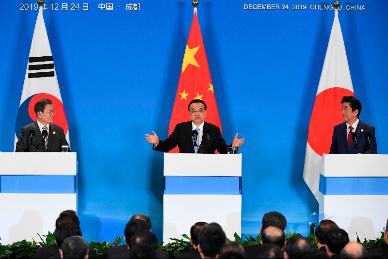 中国总理李克强（中）在第八次中日韩领导人会议后召开的联合新闻发布会上发表讲话，韩国总统文在寅（左）和日本首相安倍晋三（右）在聆听。（图：法新社）  