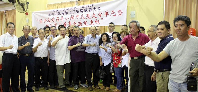 陈德钦（左六）与槟马华领袖及其他出席者，一起高呼拒绝在华小四年级国文课本中纳入爪夷字单元的口号。