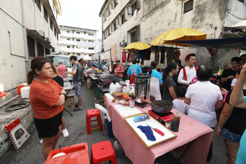 民众穿梭在大会堂的后巷，购买新村美食，以及参与制作月饼和裹粽子，令巷子呈现生机勃勃的一面。