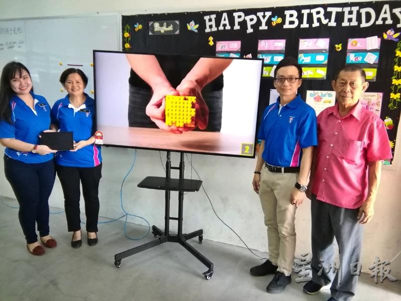 右起吕瑞麟、熊志崴、刘锦治和黄雪玉展示安装在课室里的60寸4K精明电视机。（图：星洲日报）