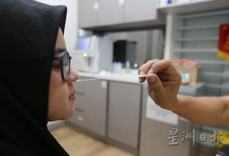 医生拿取患者的鼻涕以检测流感病毒。