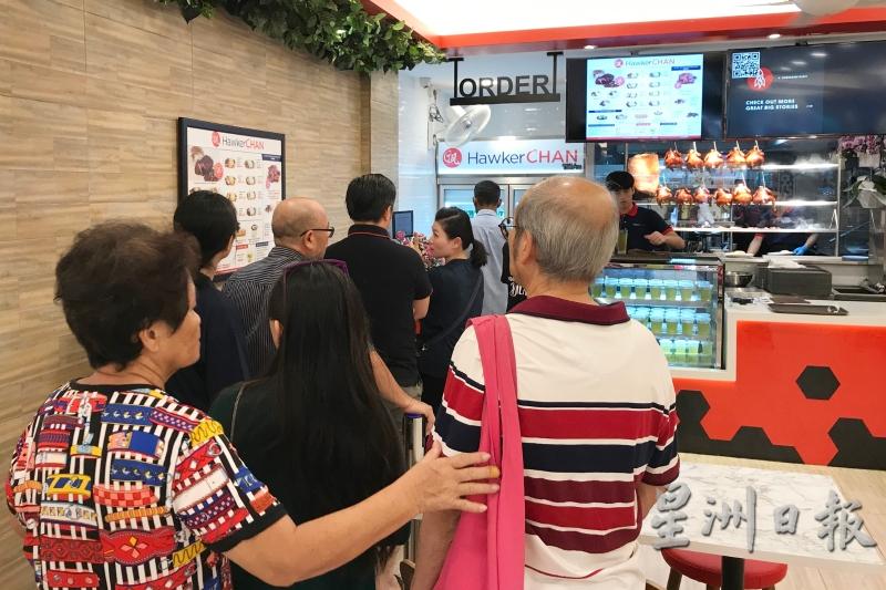 “了凡香港油鸡饭”一开业，就吸引不少饕客上门，排队准备点餐。（图：星洲日报）