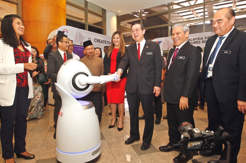 林冠英（右三）出席布城金融科技嘉年华时与机器人握手，右二为财政部秘书长丹斯里阿末峇德里。