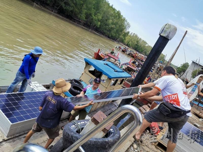 组员们同心协力，将太阳能板从船上搬上码头。