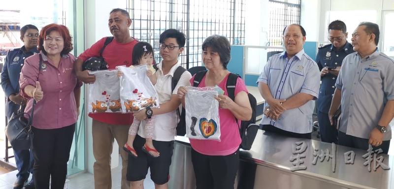黄丽娟（左）赠送邦咯岛的T恤给离岛的旅客。
