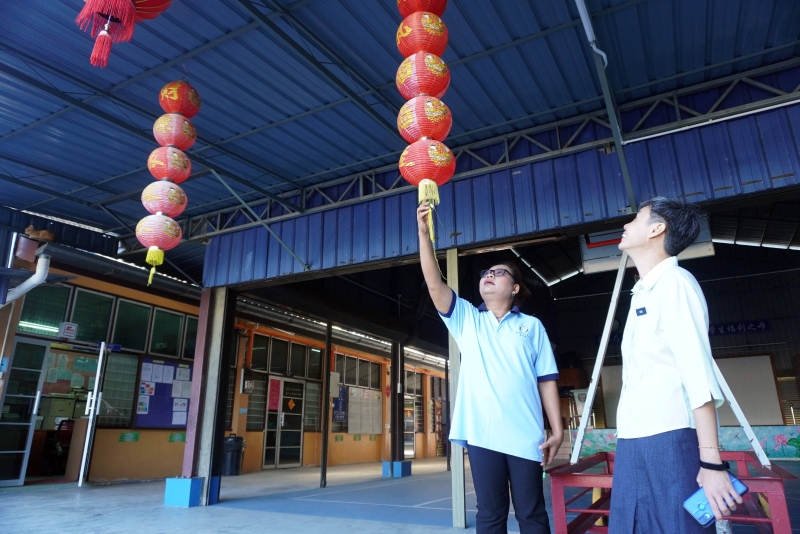 农历新年即将到来，加娘（左）和公益华小校长杨力盈在讨论校园的新春布置。