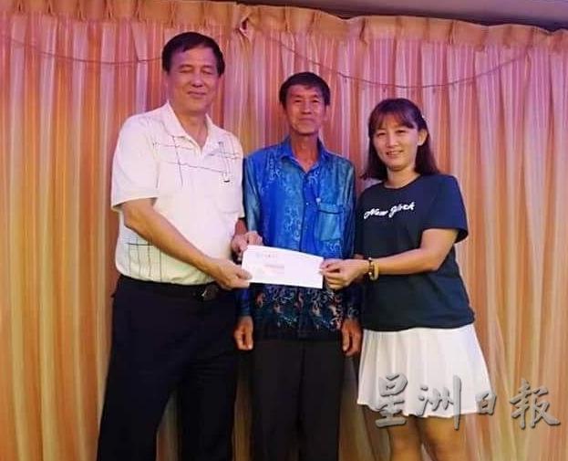 刘绵花(右)在梁慎华(中)见证下,移交款项给郑清华。(图:星洲日报)