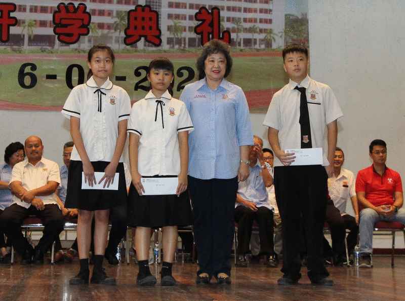 建国副董事长拿督林雅敏（右二）颁发副首席部长拿督刘静芝领养计划奖学金予受惠学生。
