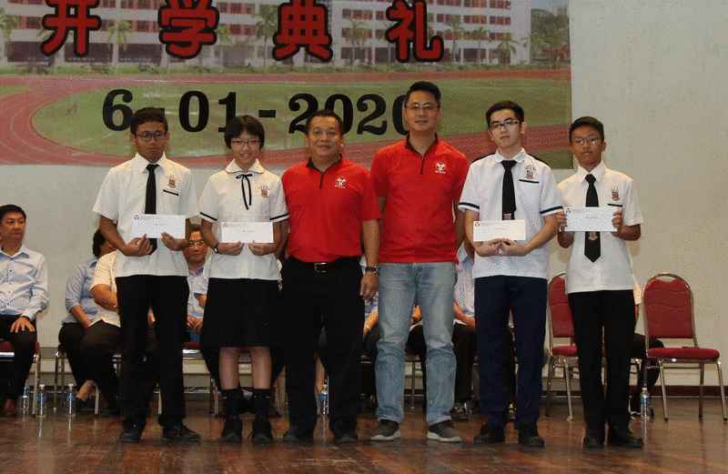 建国校友会主席林天宾（左三）及副主席余汉祥（右三）颁发校友会领养计划奖学金予受惠的学生。