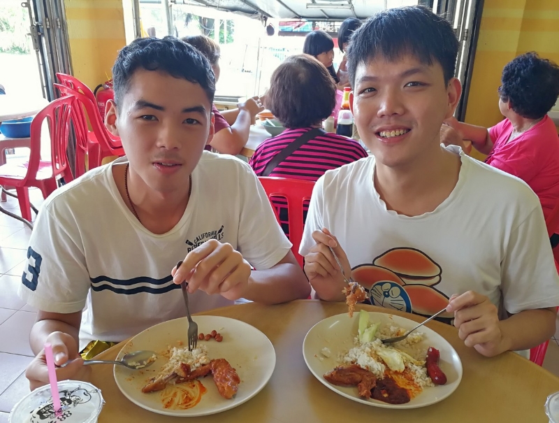 陈韦菘（右）与堂弟陈韦斌相约品尝美味的椰浆饭及炸鸡。