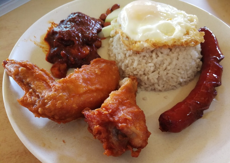 香脆炸鸡搭配香味四溢的椰浆饭及参峇酱，再配上煎蛋及香肠，就是美味又饱足的一餐。