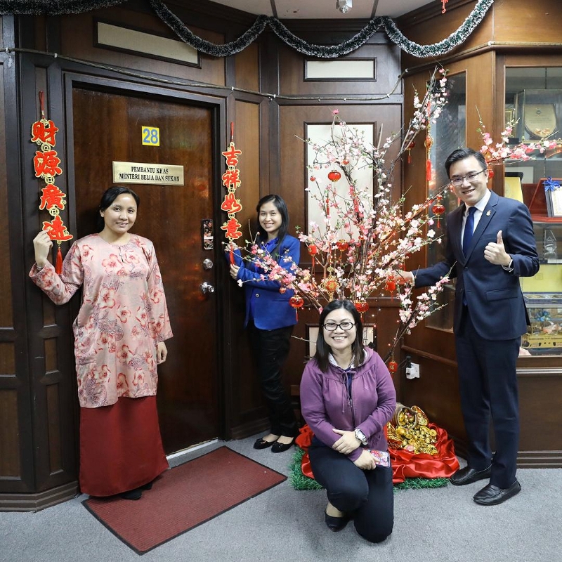 冯晋哲和来自不同种族的助理们，在换上农历新年装饰的办公室前合照。