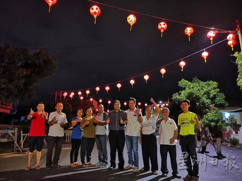 黄文标（右四起）、吴国锋、罗国忠、巴占村委会成员和村民对于夜间亮起的灯笼，竖起拇指赞好。