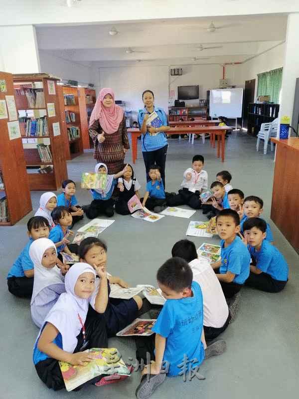 由不同民族组成的其中一班一年级学生在图书馆上阅读课。
