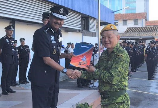 纳沙鲁丁（左）颁发表扬状给去年协助警方执法的华都牙也警卫团成员刘新华。