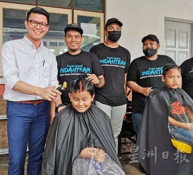 陈家兴（左）安排理发师替学生剪头发，让迎接新学年的到来。