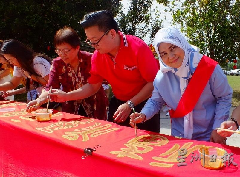 热爱教育的罗茜达（右一）还现场挥毫“福”字，右二为其华裔职员蔡松强。