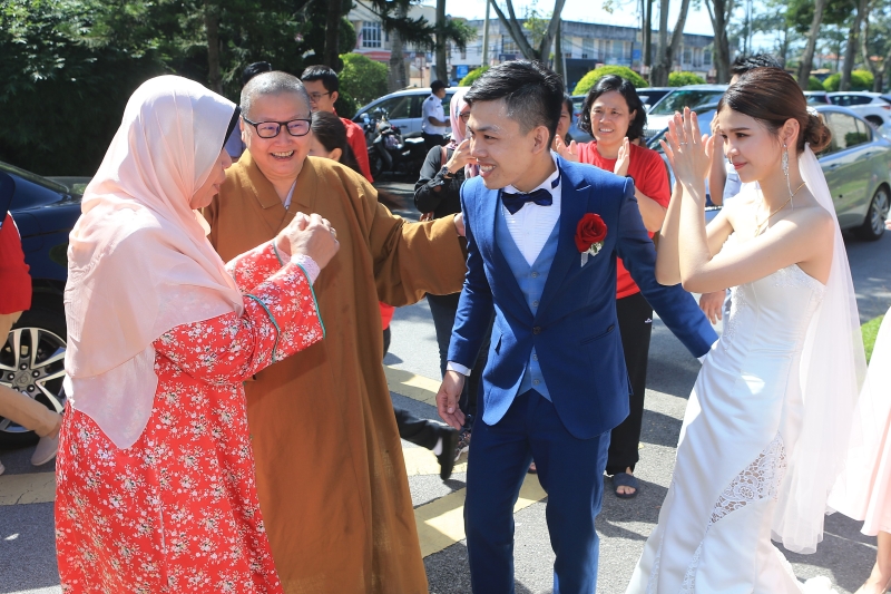 祖莱达（左一）参访东禅寺那天，巧遇有一对新人在此拍婚纱照，前者也亲切向前祝贺。