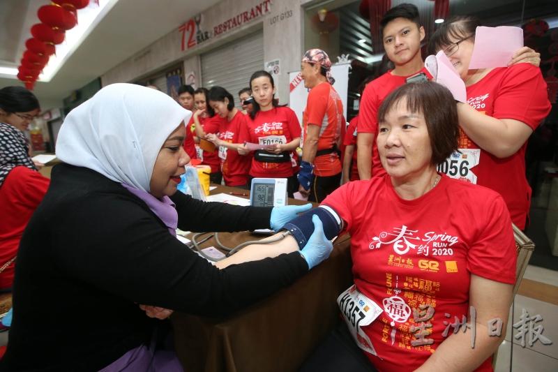 刘永美专科医疗中心的护理人员正为参赛者量血压。（图：星洲日报）