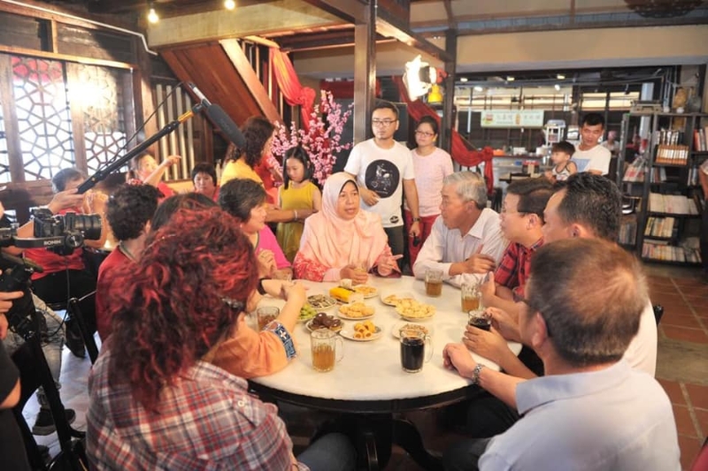 在仁嘉隆幸福村文化馆拍完贺岁短片之后，祖莱达（坐者中）与当地村民坐下来喝茶吃饼，感受华人新年的气氛。