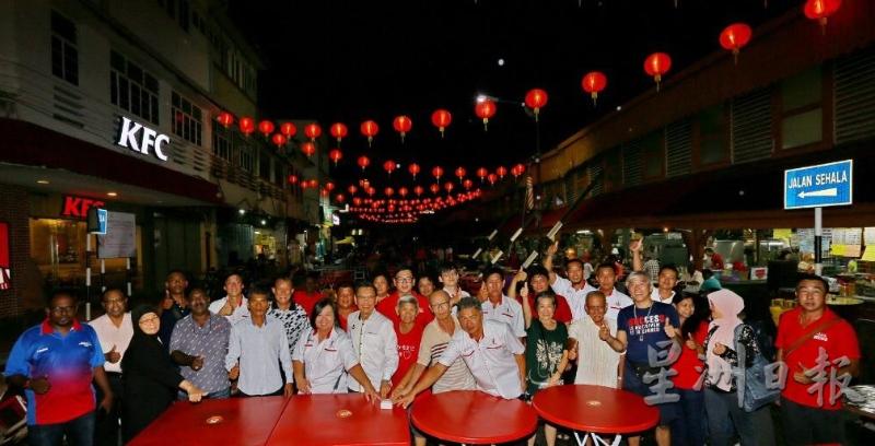 廖泰义（左六）在服务团队与村委会主席成员陪同下，进行太平美食街不夜天公市新春亮灯仪式。（图：星洲日报）