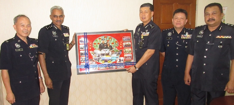 苏瑞斯（左二）在霹雳州社区安全与防范罪案组高级警官陪同下赠送纪念品给林鸿选。左是黄沐发；右起卡玛鲁丁、黄光顺。