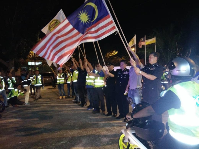 林鸿选（右一）参与社警活动，于2019年9月在巴占治安志愿公会主办的霹雳州团结大巡逻活动上，与众人联合主持挥旗礼。