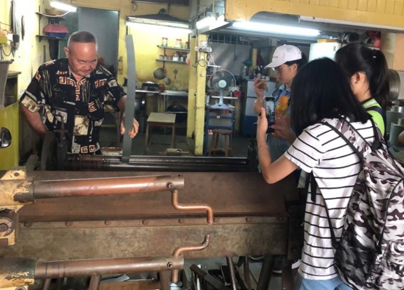 学员采访和摄录打铁匠的工序，准备制作视频。