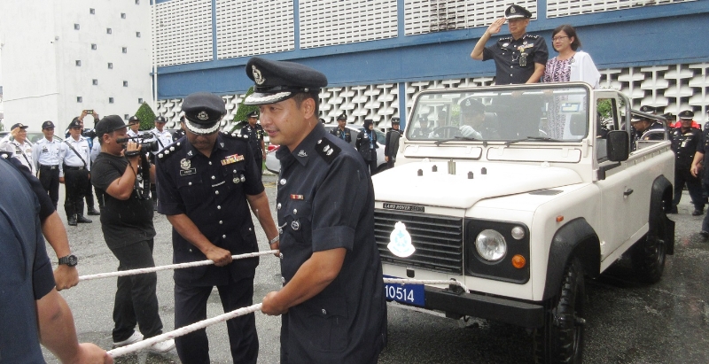 在众多警官拉车下，林鸿选与李美霞站在吉普车上向欢送的警官致敬。　