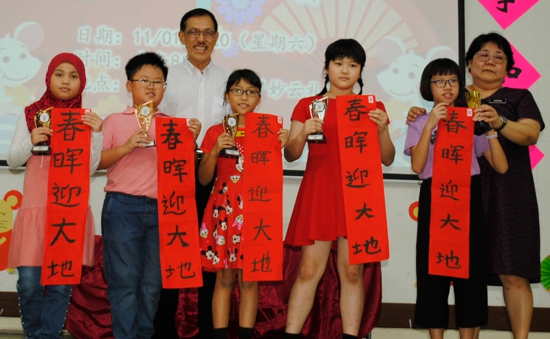 马来女学生菲佳（左一）荣获五年级组安慰奖，她和其他优胜者领奖后，和张志雄（左三）与庄月丽（右一）分享喜悦。