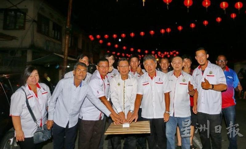 廖泰义（前排中）在服务团队与村委会主席陪同下为保阁亚三新村挂红灯迎春进行亮灯。