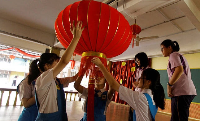 Students hang up a Chinese New Year lantern decoration at SMK Pusat Bandar Puchong 1. Photo courtesy: Bernama