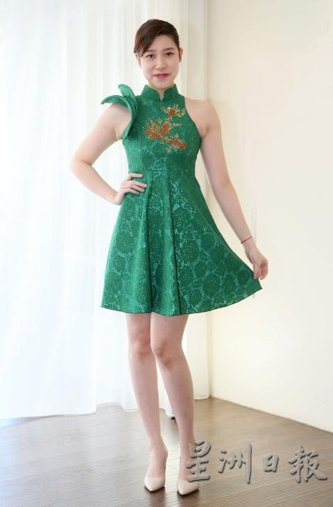 绿色旗袍款伞裙，袖子大玩不规则花样，单边缀以荷叶边彰显女王气息，裙身贴上水晶金鱼，又保留了传统的元素。
