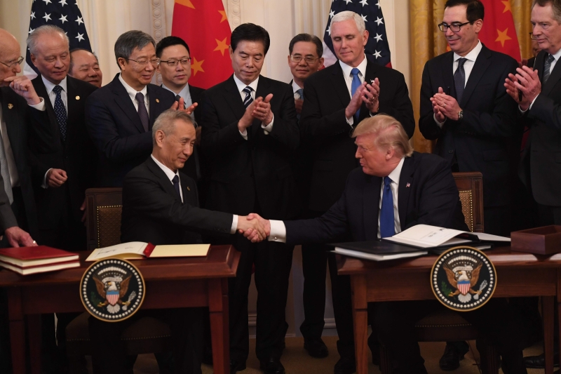 特朗普与刘鹤签署中美第一阶段贸易协议后，握手祝贺。（法新社照片）