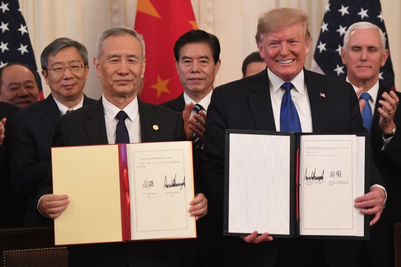 美国总统特朗普和中国国务院副总理刘鹤签署中美第一阶段贸易协议。（法新社照片）