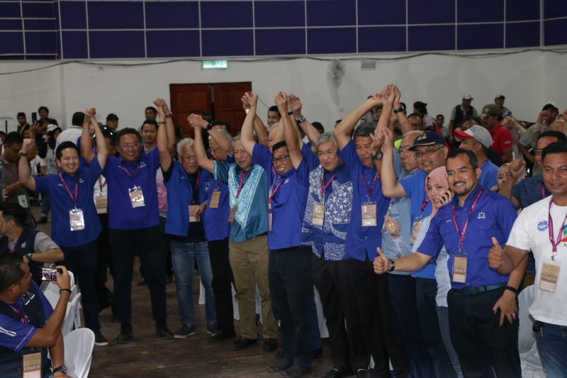 国阵巫统领袖陪同阿拉明（左六）抵达开票中心，应摄影记者要求，举手欢庆胜选。
