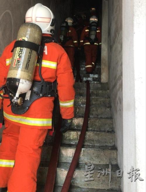 消拯人员佩戴氧气筒进入火灾现场进行检查。（图：星洲日报）