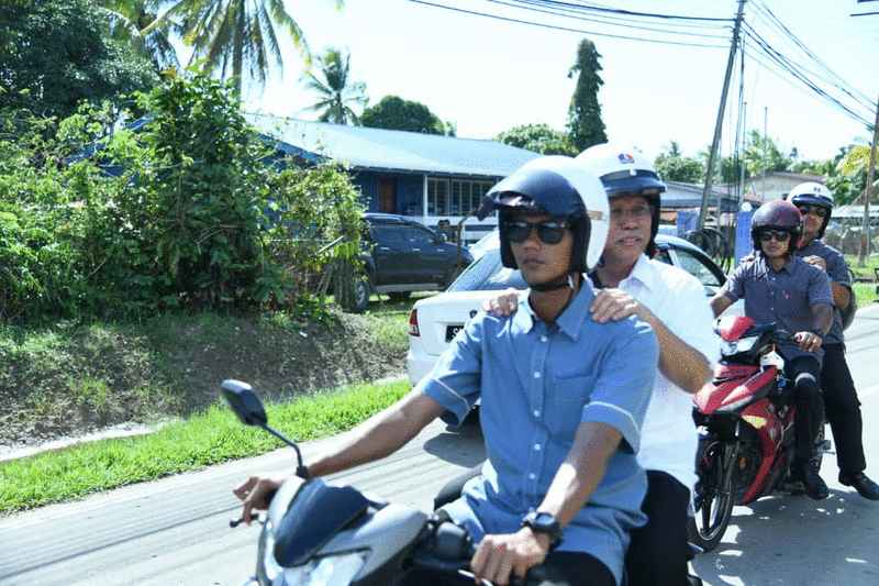 沙菲益乘坐护卫驾驶的摩托车前往各个投票中心视察。