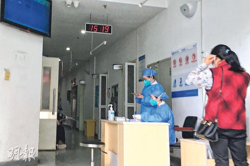 在深圳市第三人民医院，全部职员均戴口罩，发烧门诊接待处位置的职员更穿上防护帽和防护衣。（图：明报）