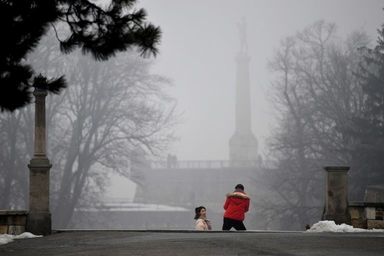 A tourist poses for a picture near "The Victor" (Pobednik) monument in Belgrade. AFP