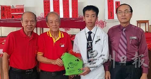 公教中学学生张文康（右二）参与挥写春联，宋群礼（左起）与沈墨义代表工委会赠礼物奖励，右为林兴南。