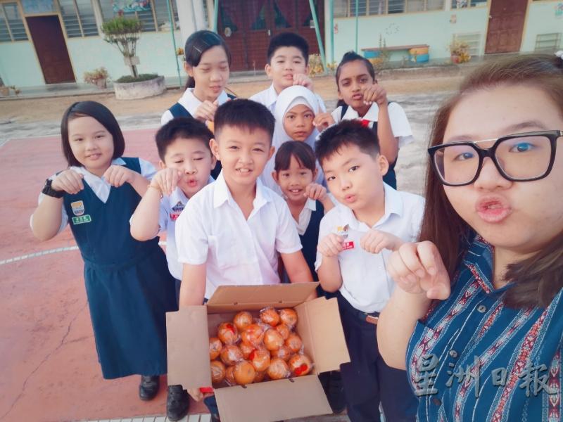 为贺年短片身兼多职的谢汶惠（右）与全校9名华巫印学生在拍片期间扮鼠合照。