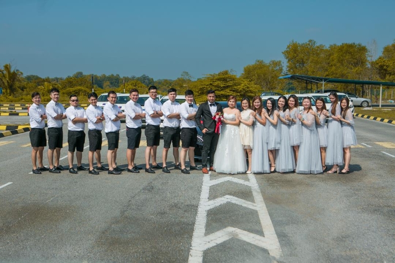 为了纪念这特别的一天，一对新人特意前往考车场，与伴郎伴娘们一同拍摄一组婚纱照。