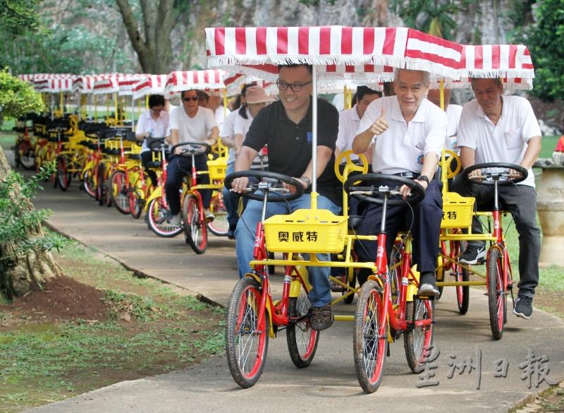 曾耀棠（右）和庄建裕（左）与极乐社众理事社员同在景色清幽的极乐洞体验骑脚车的乐趣。