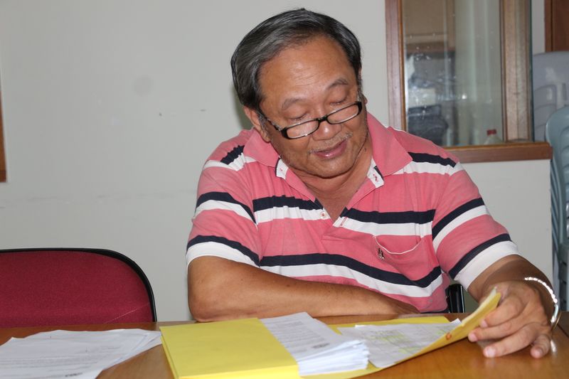诗巫与加帛省华小董联会主席郑尚魁查阅已上交报告的会员校名单。

