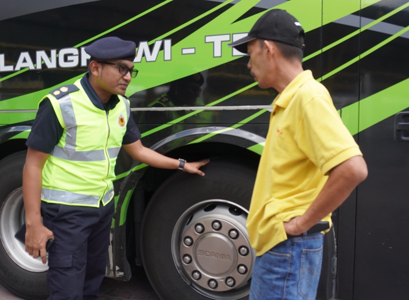 玻州陆交局副局长马哈兹（左）向司机了解长巴轮胎等情况。