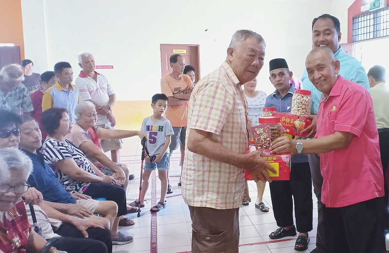 托斯林（右）是本区第一位在华人新春佳节前夕，派送年柑、年饼及红包给华裔乐龄人士的友族州议员。