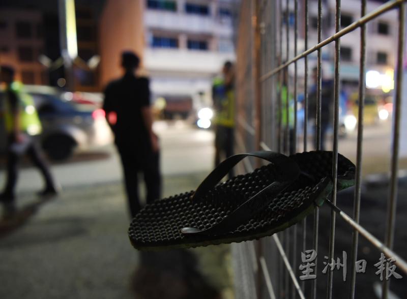 相信是为了逃避执法人员检查，有民众不惜爬篱笆逃走，并留下了拖鞋。