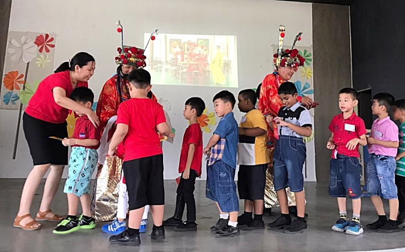 化身财神爷的岑麒平、刘子兴派红包给学生。