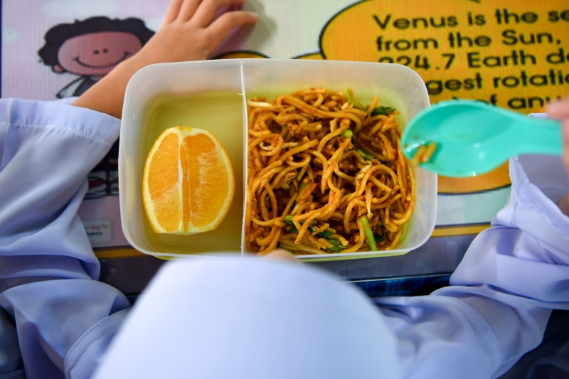 免费食物补助改善计划在全马B40学生比例较高的学校推行，预计有3万7000名学生受惠。图为马六甲野新一所国中SK Batu Gajah在计划首日为学生准备的炒面及橙子。